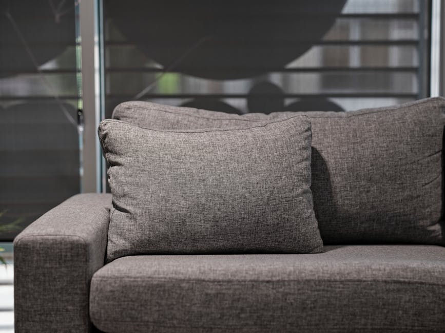 Elegant grey sofa with plush cushions in a contemporary living room setting.
